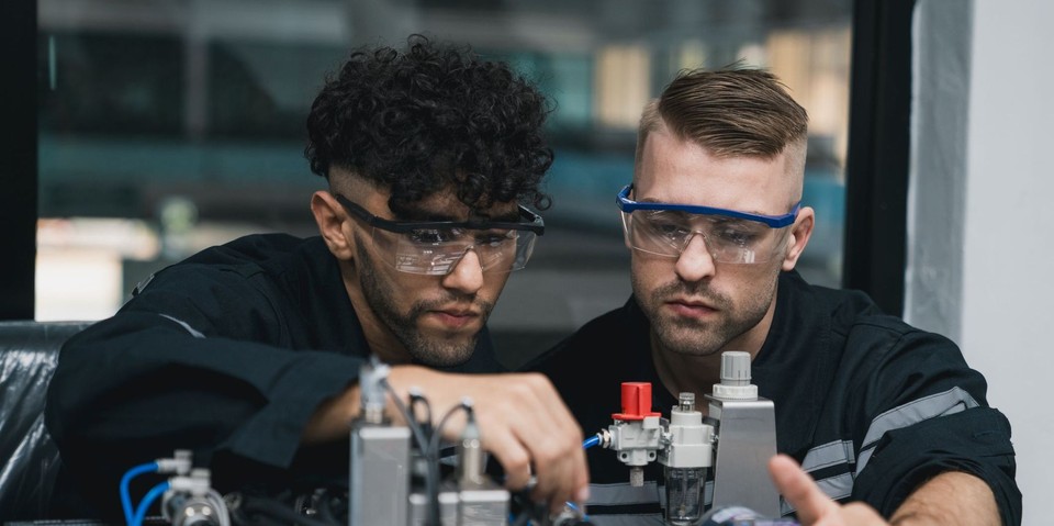 Angehende Ingenieur:innen montieren einen Roboterarm. (NewSaetiew / iStock)